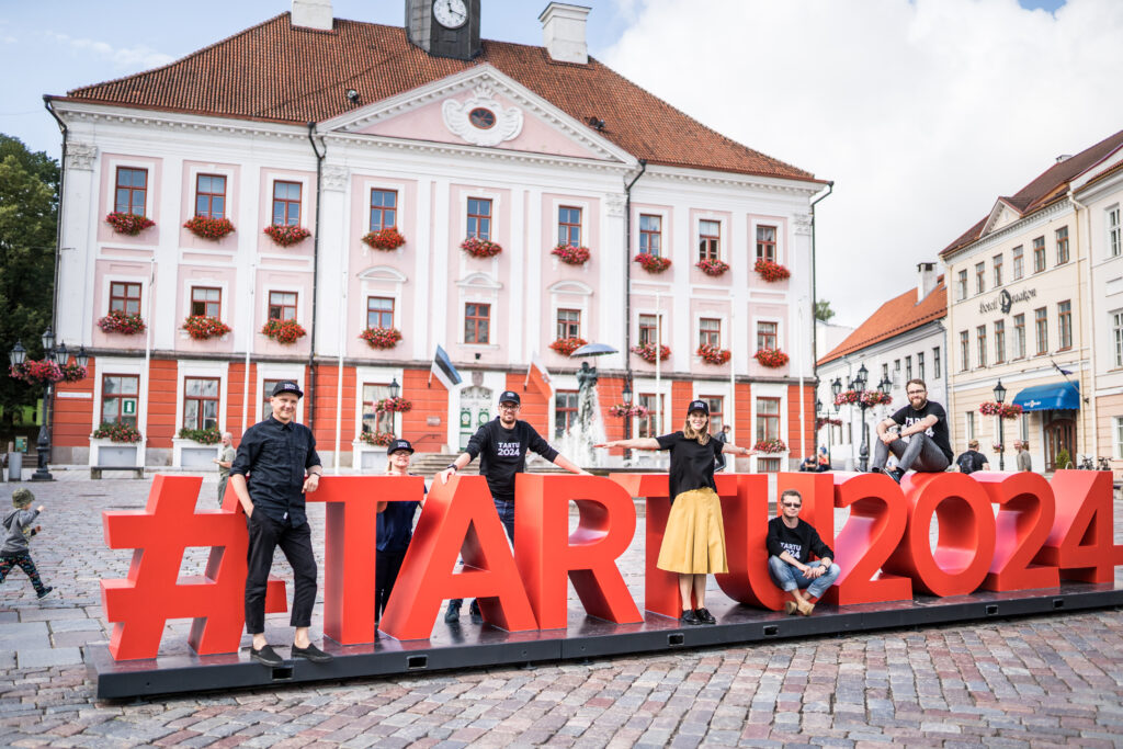 Tartto on vuonna 2024 Euroopan kulttuuripääkaupunki. Kuvassa sen aihetunniste ja ihmisiä Tarton Raatihuoneen torilla.